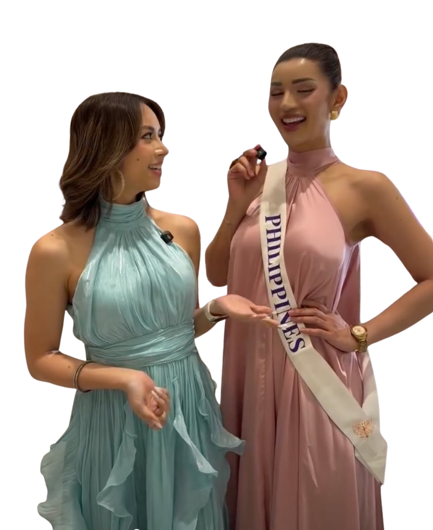 Two women in evening gowns sharing a laugh during an interview