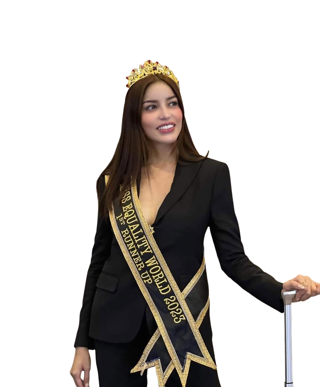 Crowned titleholder in a black suit and sash