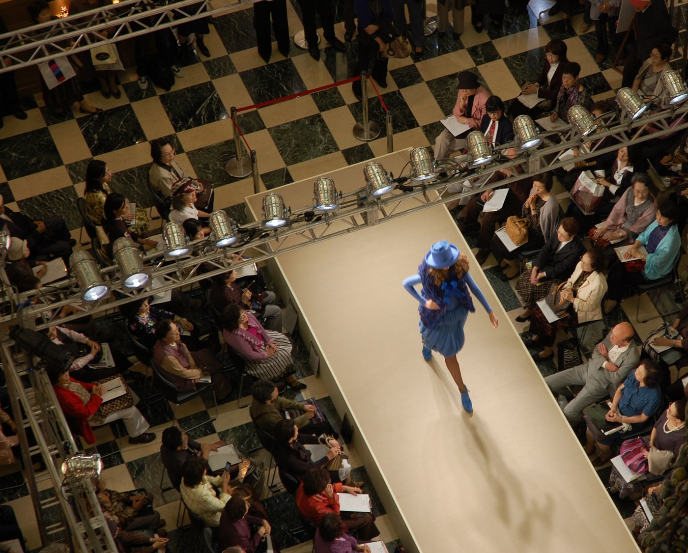 Reference image: a runway show with the audience seated along the catwalk
