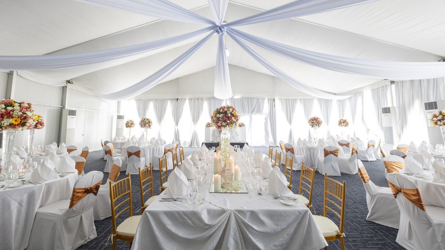 White-draped event hall set for a banquet